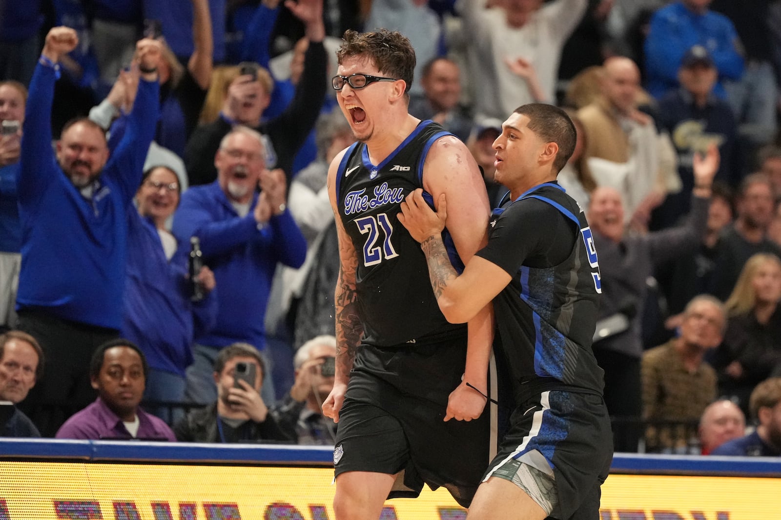 Saint Louis' Robbie Avila (21) and Ishan Sharma, right, celebrate after defeating George Washington in an NCAA college basketball game Tuesday, Jan. 27, 2026, in St. Louis. (AP Photo/Jeff Roberson)