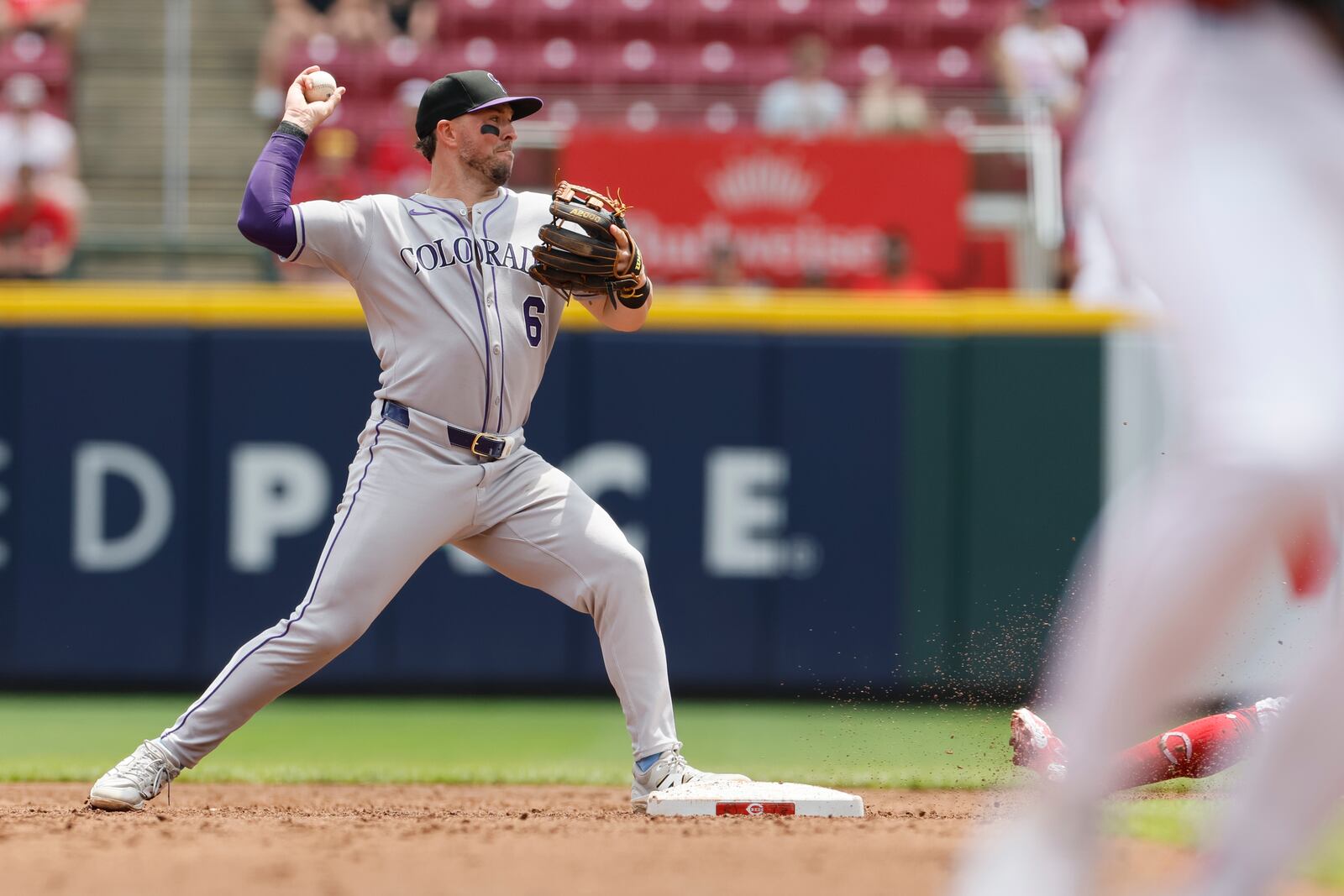 Colorado Rockies second baseman Kyle Farmer turns the first half of a double play against Cincinnati Reds' Matt McLain during the third inning of a baseball game, Sunday, July 13, 2025, in Cincinnati. (AP Photo/Jay LaPrete)