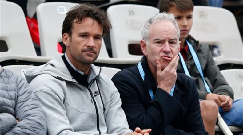 Former American tennis ace John McEnroe, right, watches Canada's Milos Raonic in the fourth round match of the French Open tennis tournament against Spain�s Albert Ramos-Vinolas at the Roland Garros stadium in Paris, France, Sunday, May 29, 2016. (AP Photo/Christophe Ena)