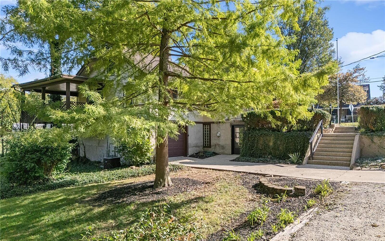 The two car tandem garage is on the basement level and there is an exterior door that walks into the finished part of the basement. Steps lead to a walkway and the covered front porch. CONTRIBUTED