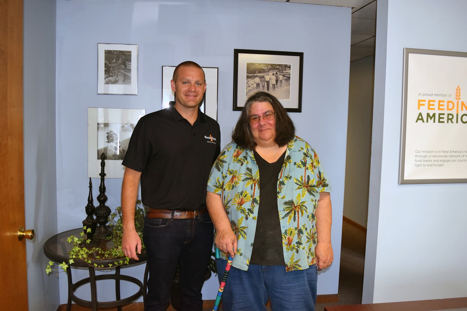 Tina Osso, Executive Director of Shared Harvest Foodbank, accepts the generous donation from Zachary Freeman of Smithfield Foods on behalf of the Kroger Company.