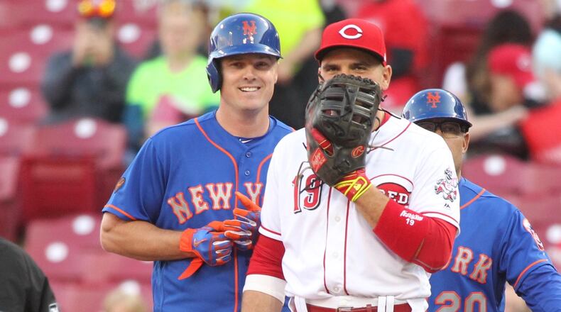The Mets’ Jay Bruce talks to his former Reds teammate, Joey Votto, after walking in the first inning on Monday, May 7, 2018, at Great American Ball Park in Cincinnati. David Jablonski/Staff