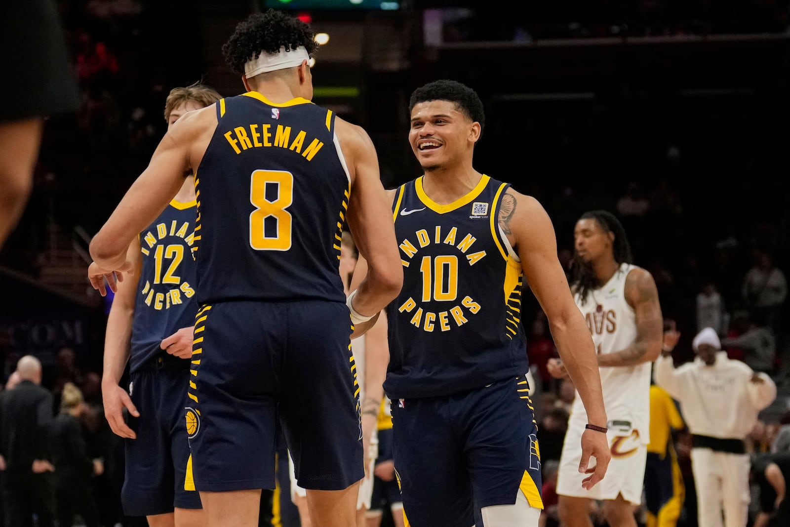 Indiana Pacers forward Enrique Freeman (8) and guard RayJ Dennis (10) celebrate after the Pacers defeated the Cleveland Cavaliers in double overtime in an NBA basketball game Sunday, April 13, 2025, in Cleveland. (AP Photo/Sue Ogrocki)