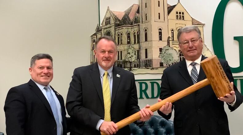 Former board president Dick Gould passes the gavel to commissioner Tom Koogler, who will serve as president for 2022. Rick Perales (left) will serve as vice president.