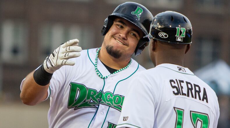 Hot-hitting Dragons first baseman Ruben Ibarra celebrates a third-inning single with coach Jefry Sierra during the Dragons' 8-5 loss to Great Lakes on Wednesday at Day Air Ballpark. Jeff Gilbert/CONTRIBUTED