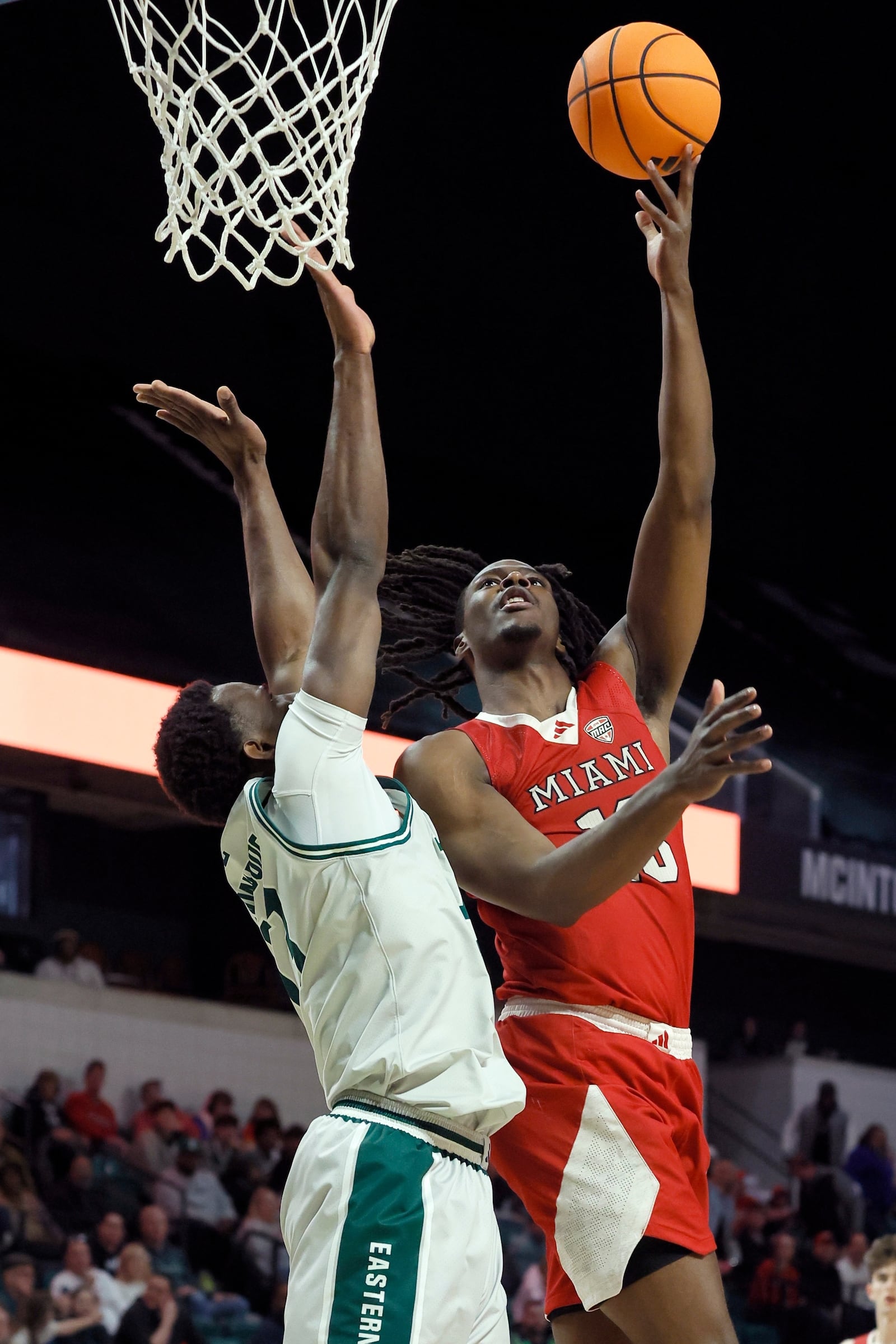 Miami (OH) forward Antwone Woolfolk, right, takes a shot over Eastern Michigan forward Godslove Nwabude, left, during the first half of an NCAA college basketball game, Tuesday, Feb. 24, 2026, in Ypsilanti, Mich. (AP Photo/Duane Burleson)