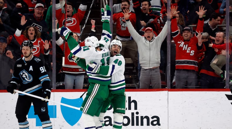 Carolina Hurricanes' Jordan Staal (11) is celebrates after his winning goal with teammate Jordan Martinook (48) with Utah Mammoth's Mikhail Sergachev (98) nearby during the third period of an NHL hockey game in Raleigh, N.C., Thursday, Jan. 29, 2026. (AP Photo/Karl DeBlaker)