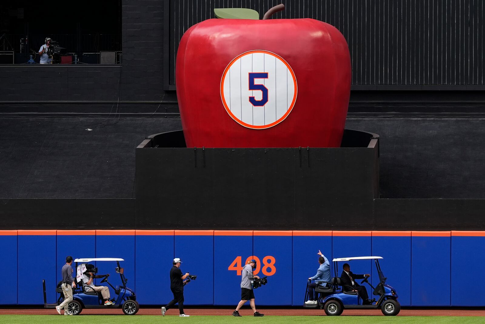 Former New York Mets third baseman David Wright rides on a golf cart, 2nd right, after a ceremony ahead of a baseball game against the Cincinnati Reds, Saturday, July 19, 2025, in New York. (AP Photo/Yuki Iwamura)