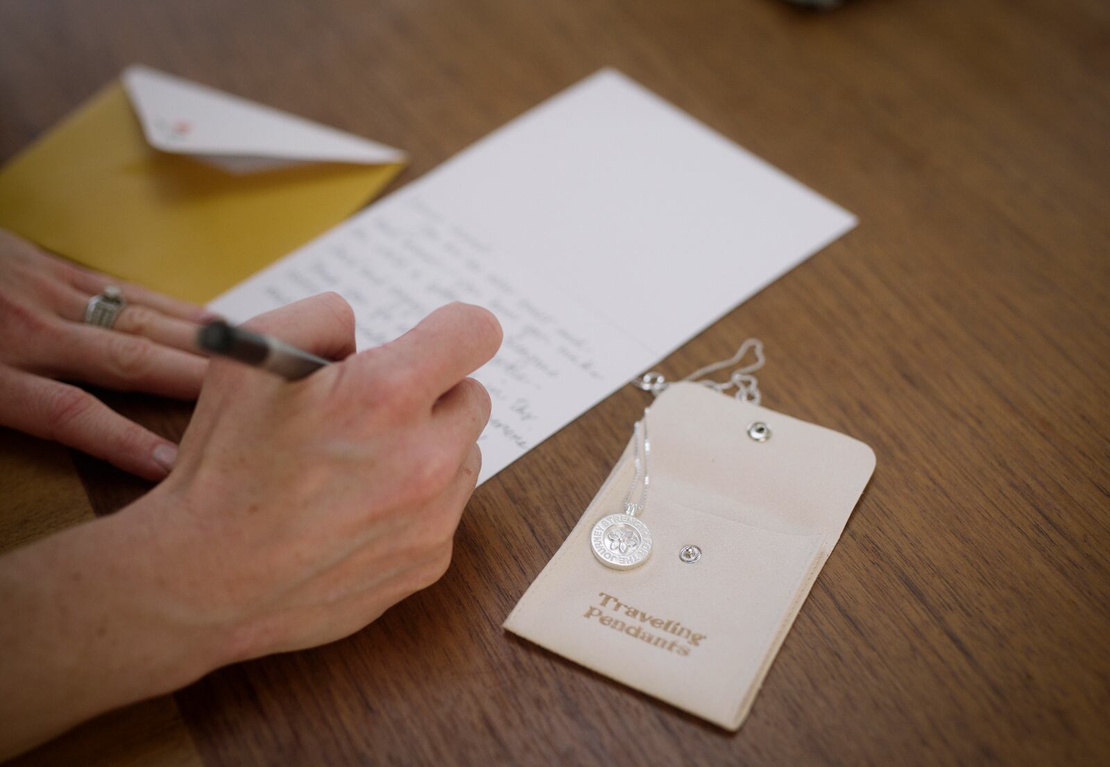 A handwritten note sends strength along with a Traveling Pendant — designed to be worn and shared, each pendant collects stories along its journey, with every new wearer adding a chapter and becoming a link in a growing chain of support. CONTRIBUTED
