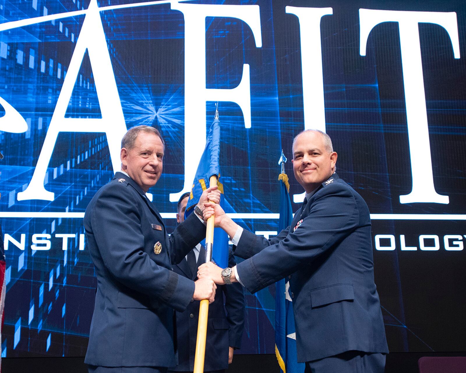 Lt. Gen. James Hecker (left), Air University commander and president, presents the Air University Detachment 1 (Air Force Institute of Technology) guidon to Col. Paul Harmer during a change-of-command ceremony July 28 at the AFIT campus on Wright-Patterson Air Force Base. Harmer assumes command from Col. Paul Cotellesso, who retired after 30 years of military service. U.S. AIR FORCE PHOTO/R.J. ORIEZ