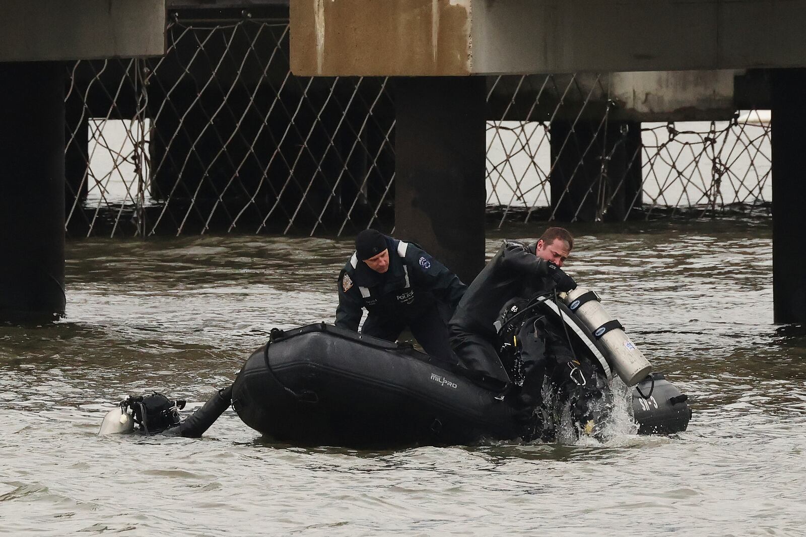 A New York Police Department scuba team exits the water, Friday, April 11, 2025, after diving at the site where a sightseeing helicopter crashed a day earlier into the Hudson River in Jersey City, N.J. (AP Photo/Yuki Iwamura)