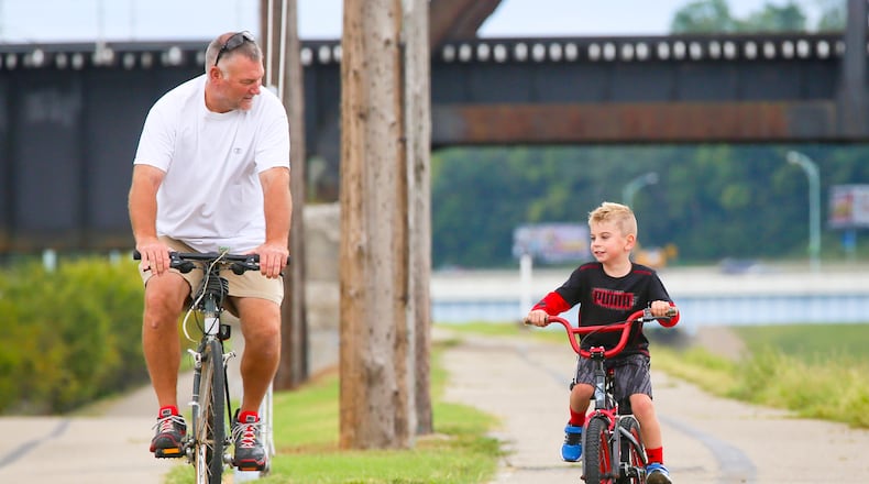 Pete Kreke and his step-grandson Brady Cecil, 5, ride along the Great Miami River bike path in Hamilton, Saturday, Sept. 12, 2015. Brady had just received a new Star Wars bike and was trying it out. GREG LYNCH / STAFF