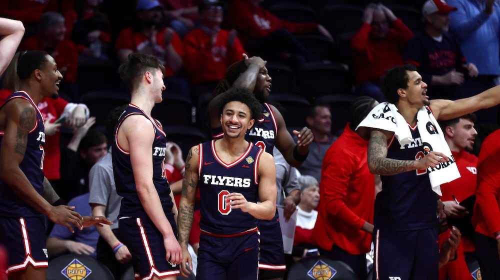 Dayton players, including Javon Bennett, center, smile during the final minutes of a victory against Bradley in the first round of the National Invitation Championship on Wednesday, March 18, 2026, at Carver Arena in Peoria, Ill. David Jablonski/Staff
