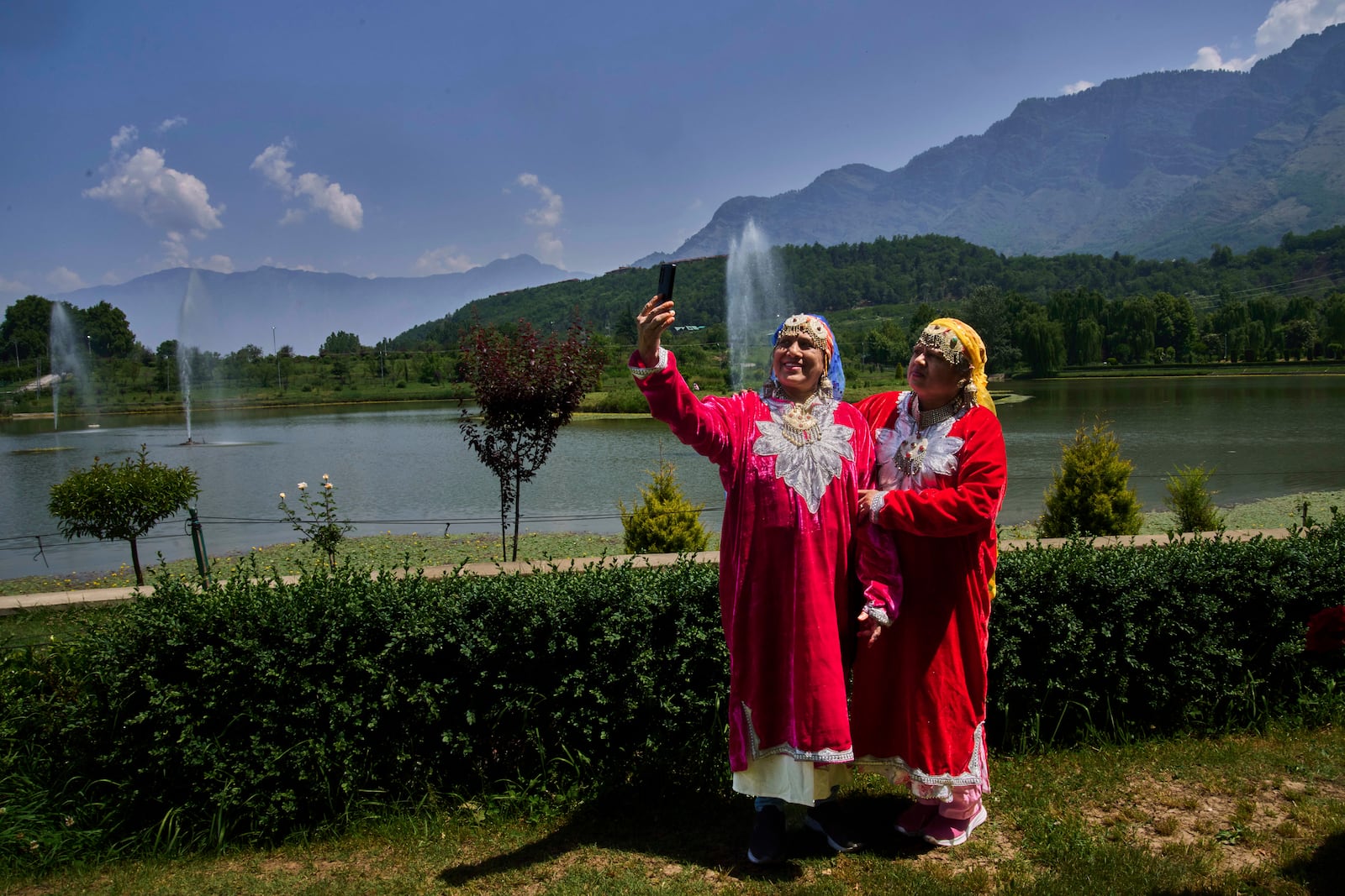 Surekha Dube, left, and Sunita Kamble, tourists from the Indian state of Maharashtra, take a selfie inside a deserted garden in Srinagar, Indian controlled Kashmir, India, Tuesday, May 20, 2025. (AP Photo/Dar Yasin)