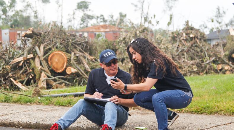Steve Cooper and Malyssa Suarez, both with the Federal Emergency Management Agency, conduct a joint preliminary assessment of tornado-damage Wednesday at the Westbrooke Village Apartments in Trotwood. CHRIS STEWART / STAFF