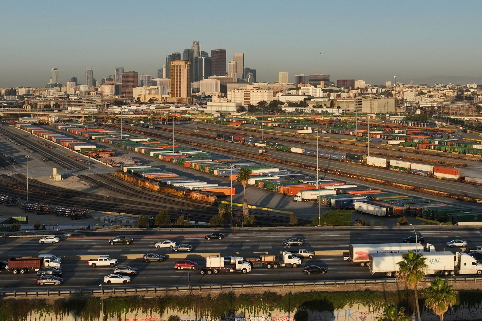Traffic flows on Interstate 5 past shipping containers near downtown Los Angeles, Tuesday, April 8, 2025. (AP Photo/Jae C. Hong)