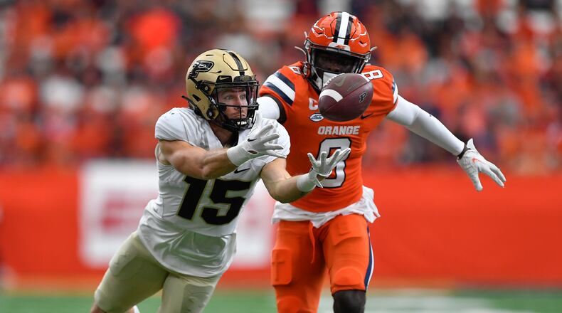 Purdue wide receiver Charlie Jones, left, reaches for a pass as Syracuse defensive back Garrett Williams defends during the first half of an NCAA college football game in Syracuse, N.Y., Saturday, Sept. 17, 2022. (AP Photo/Adrian Kraus)