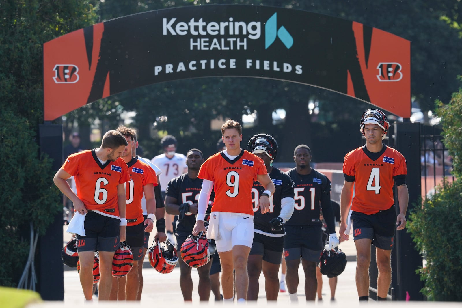 Cincinnati Bengals' Joe Burrow (9) walks to the field with teammates before practice at the team's NFL football training camp, Wednesday, July 23, 2025, in Cincinnati. (AP Photo/Jeff Dean)
