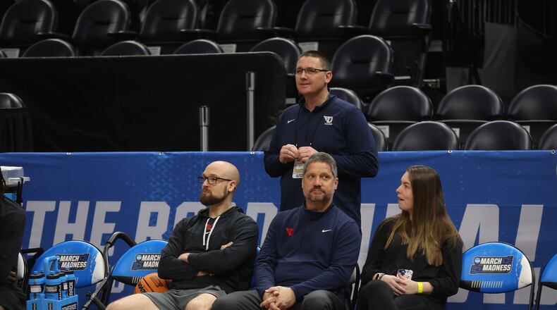 Dayton strength coach Casey Cathrall and trainers Mike Mulcahey and Shelby Davis and Athletic Director Neil Sullivan, back, talk as the team practices for the NCAA tournament at the Delta Center in Salt Lake City, Utah, on Wednesday, March 20, 2024. David Jablonski/Staff