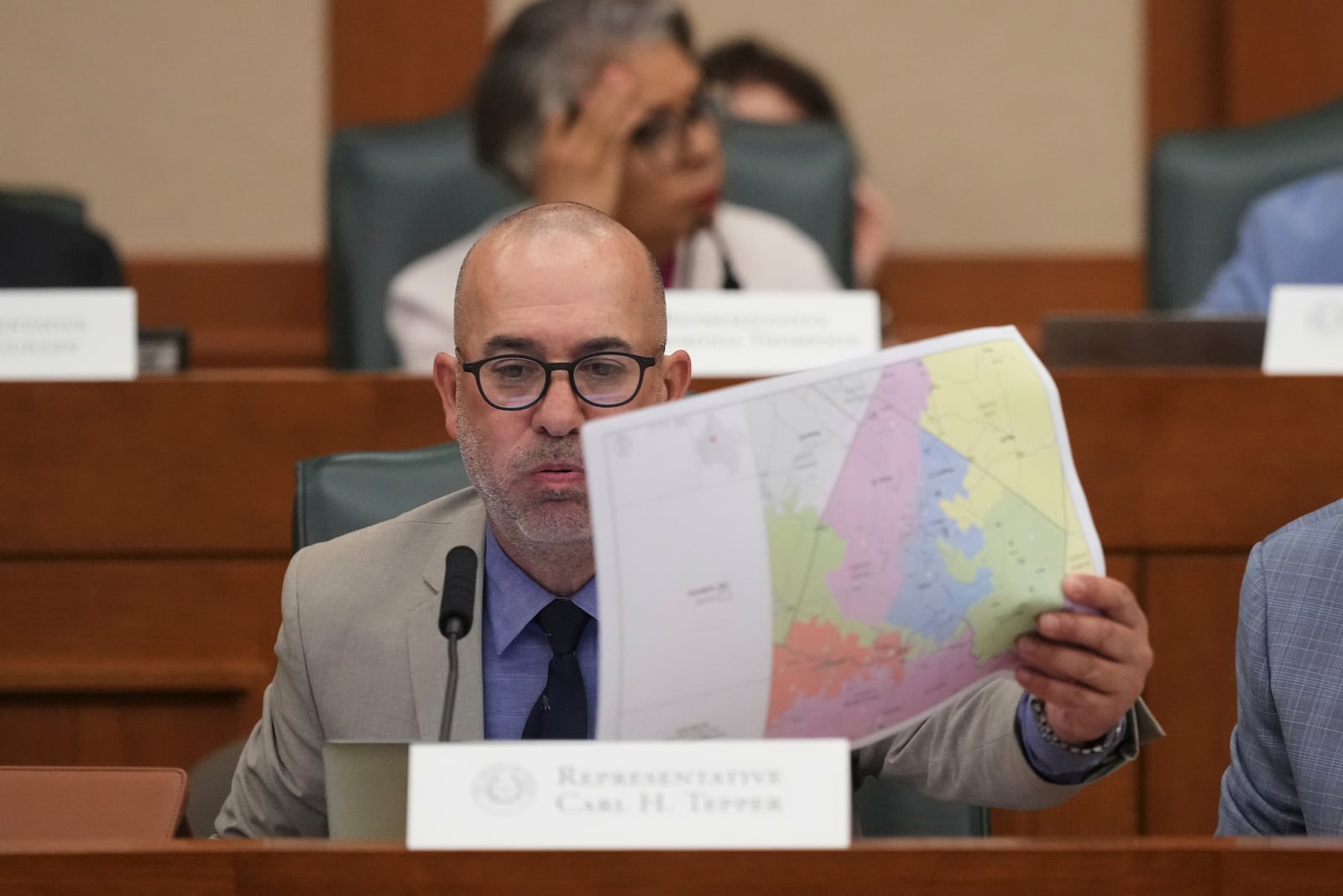 Texas state Rep. Carl H. Tepper, R-Lubbock, looks through U.S. Congressional District maps during a redistricting hearing at the Texas Capitol, Thursday, July 24, 2025, in Austin, Texas. (AP Photo/Eric Gay)