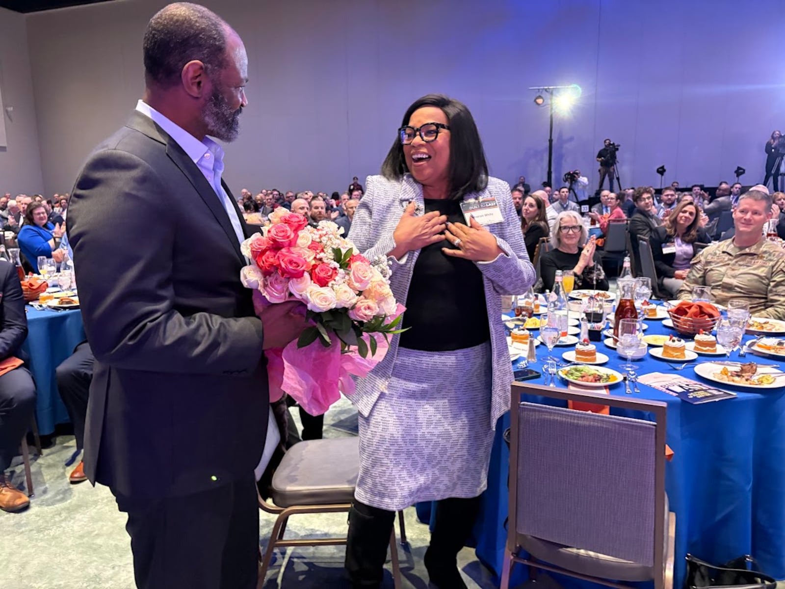 Sharon White is presented with a bouquet from her husband Donald White after learning Wednesday Feb. 4, 2026 that she has received the Dayton Development Coalition's Maureen Patterson Regional Leader Award. THOMAS GNAU/STAFF