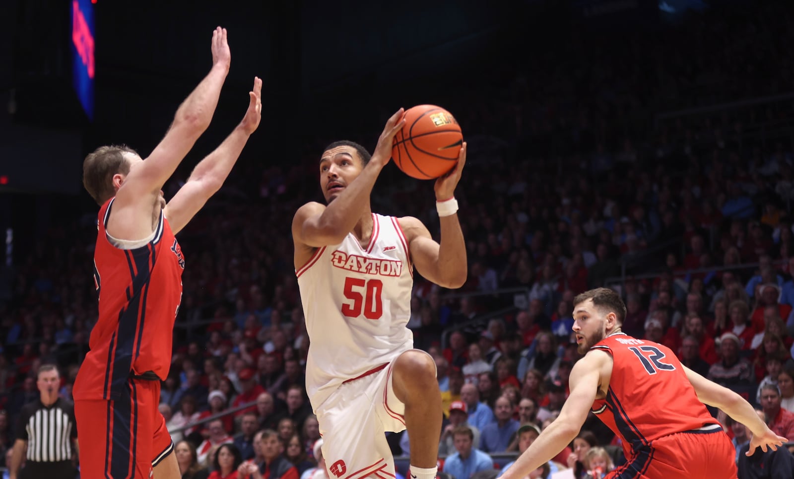 Dayton's Sean Pouedet scores against Liberty on Saturday, Dec. 20, 2025, at UD Arena. David Jablonski/Staff