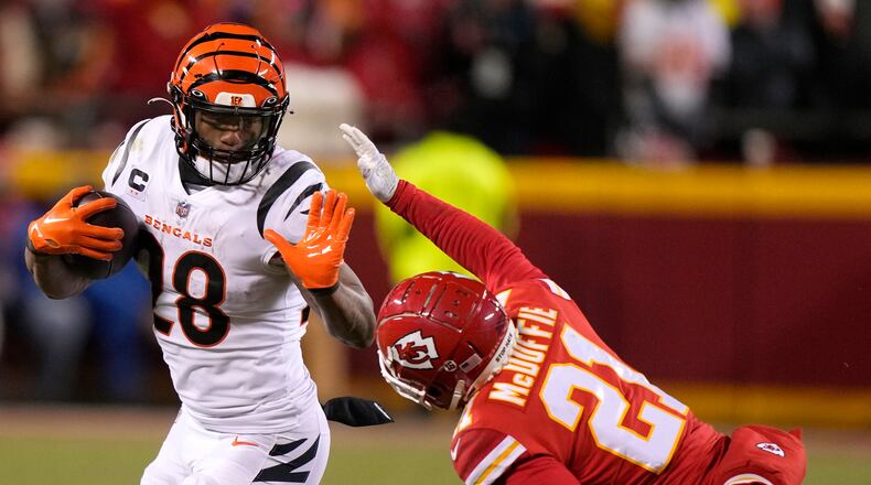 Cincinnati Bengals running back Joe Mixon (28) runs against Kansas City Chiefs cornerback Trent McDuffie (21) during the second half of the NFL AFC Championship playoff football game, Sunday, Jan. 29, 2023, in Kansas City, Mo. (AP Photo/Charlie Riedel)