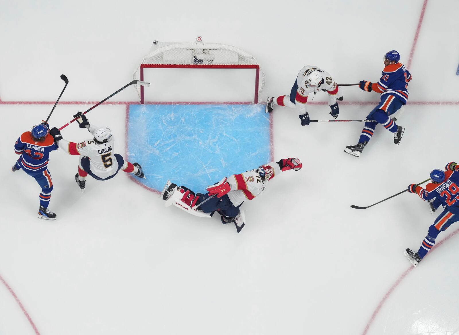 Edmonton Oilers' Leon Draisaitl (29) scores against Florida Panthers goalie Sergei Bobrovsky (72) as Aaron Ekblad (5) and Gustav Forsling (42) defend while Edmonton's Kasperi Kapanen (42) and Evander Kane (91) watch during the first overtime period in Game 1 of the NHL Stanley Cup Final, in Edmonton, Alberta, on Wednesday, June 4, 2025. (Darryl Dyck//The Canadian Press via AP)
