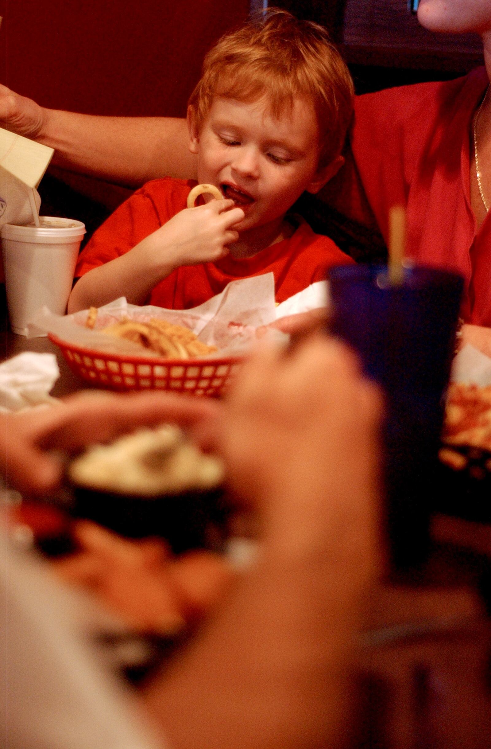 Jeremiah Suttles((cq)), 4, son of John Suttles((cq)) and Thea Suttles((cq)), eats some onion rings Friday at Trenton's new Yardbird's Southern Barbecue.  Staff photo by Cameron Knight