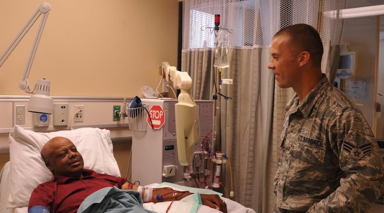 Senior Airman Jason Scoles, a dialysis technician with the 88th Medical Group, checks on his patient John Pennix as Pennix is receiving his dialysis treatment at the Wright-Patterson Medical Center. Patients go on dialysis when the kidneys are no longer able to filter and clean blood on its own. (U.S. Air Force photo/Stacey Geiger)