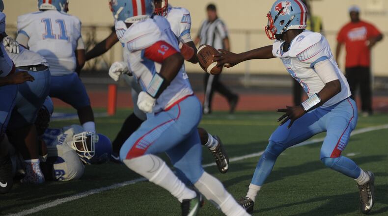 Belmont quarterback Rian Reeves pitches to teammate Dawson Martin on Aug. 24 during a 42-0 victory over Dunbar at Welcome Stadium in Dayton. MARC PENDLETON/STAFF