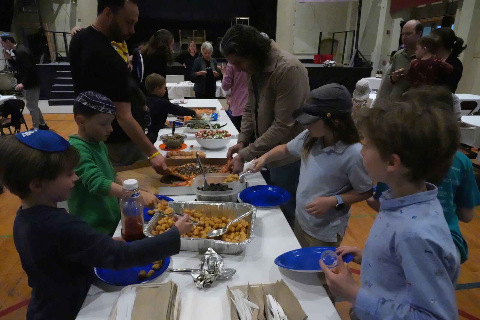 Congregants of the 104-year-old Pasadena Jewish Temple and Center which burned down in the Jan. 2025 Eaton fire, gathered for a potluck doing the Passover celebrations at the First United Methodist Church in Pasadena, Calif. on Friday, April 4, 2025. (AP Photo/Damian Dovarganes)