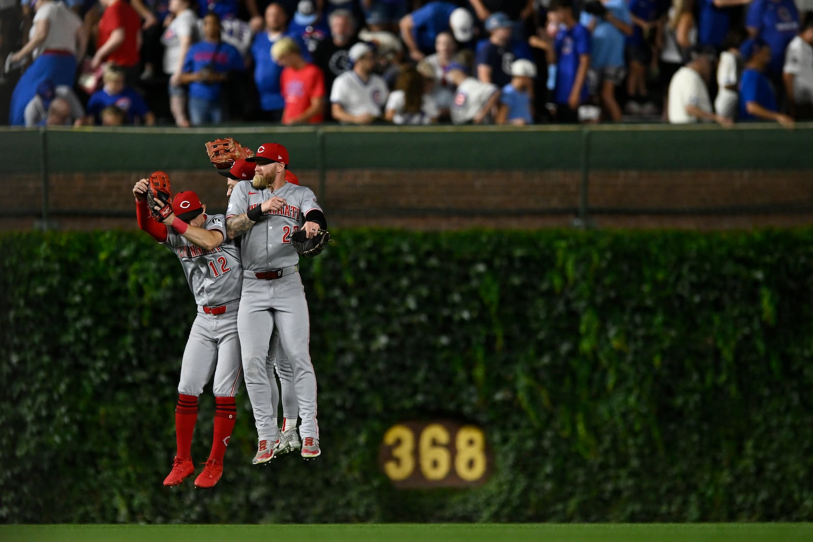 Cincinnati Reds outfielders Austin Hays, left, TJ Friedl, center, and Jake Fraley, right, celebrate after defeating the Chicago Cubs in a baseball game Monday, Aug. 4, 2025, in Chicago. (AP Photo/Paul Beaty)