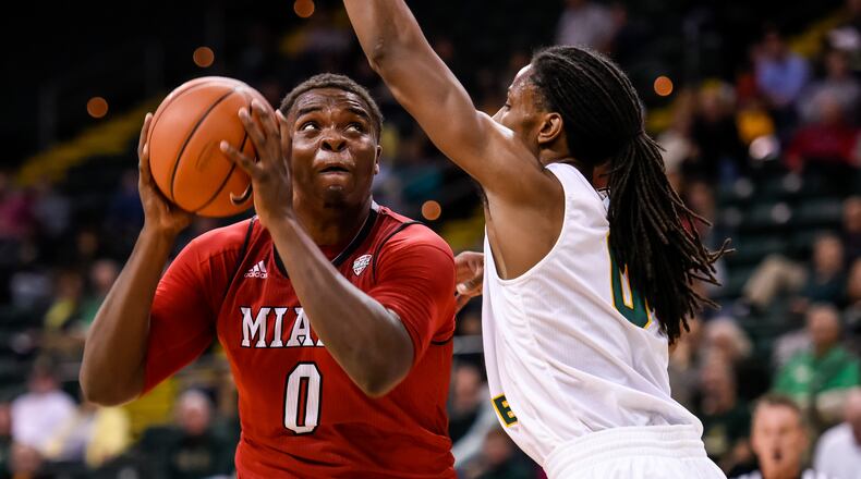 Wright State University's Steven Davis defends a shot by Miami University's Darius Harper during the first half of their game against Tuesday, Nov. 15 at the Nutter Center at Wright State University in Fairborn. NICK GRAHAM/STAFF