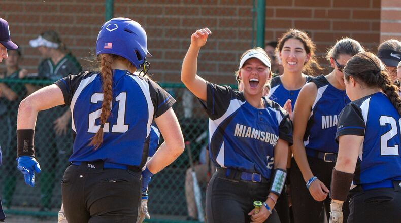 Miamisburg's Jayleigh Thomas and her teammates greet Alley Haas after the first of her two home runs in Thursday's 11-8 Division I district final victory over Mason at Hamilton High School. CONTRIBUTED/Jeff Gilbert