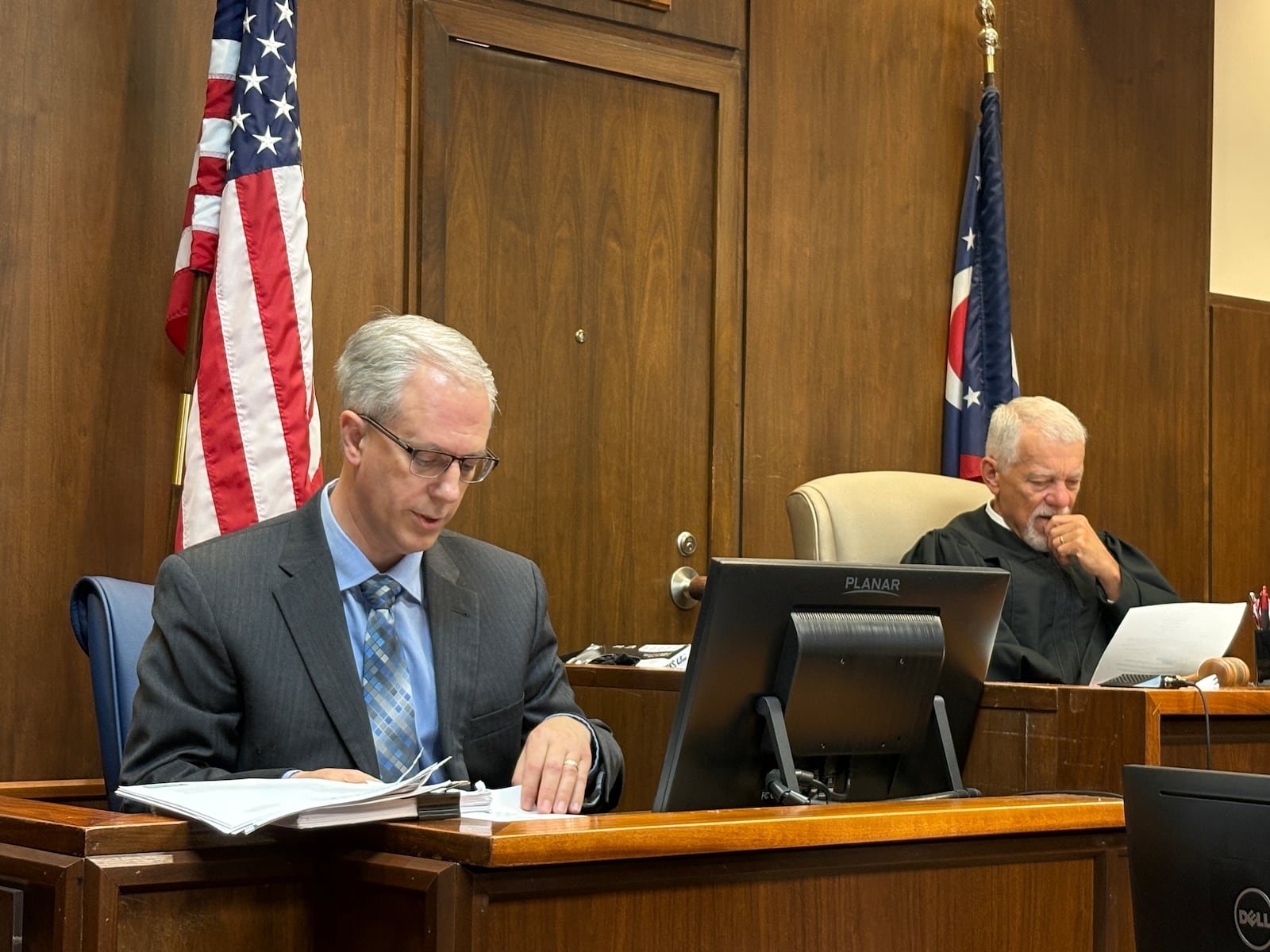 Miami Twp. Administrator Chris Snyder looks at an exhibit during his testimony Monday, March 9, 2026, in a civil case regarding the potential removal of Miami Twp. Fiscal Officer Robert Matthews. At right is visiting Judge Jonathan Hein in Montgomery County Common Pleas Court. JEN BALDUF/STAFF
