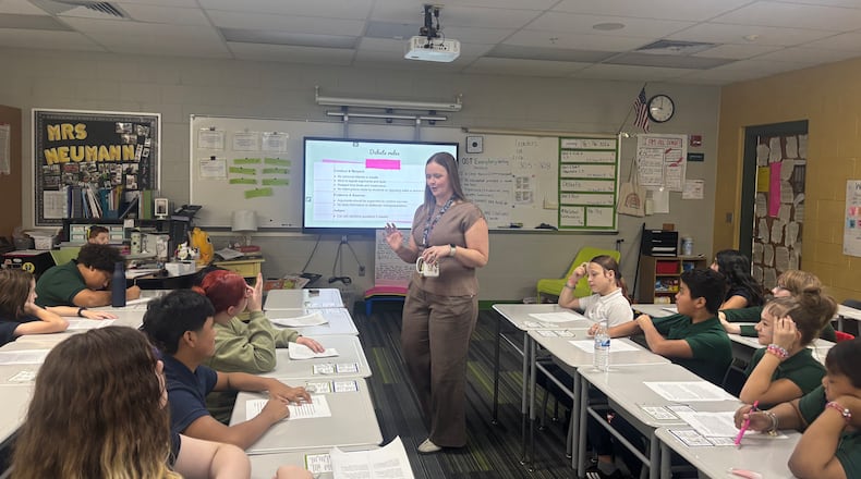 Students in Mrs. Neumann's sixth grade class at Cleveland Elementary read debate points during a class debate over chocolate being included in school lunches. Eileen McClory / staff
