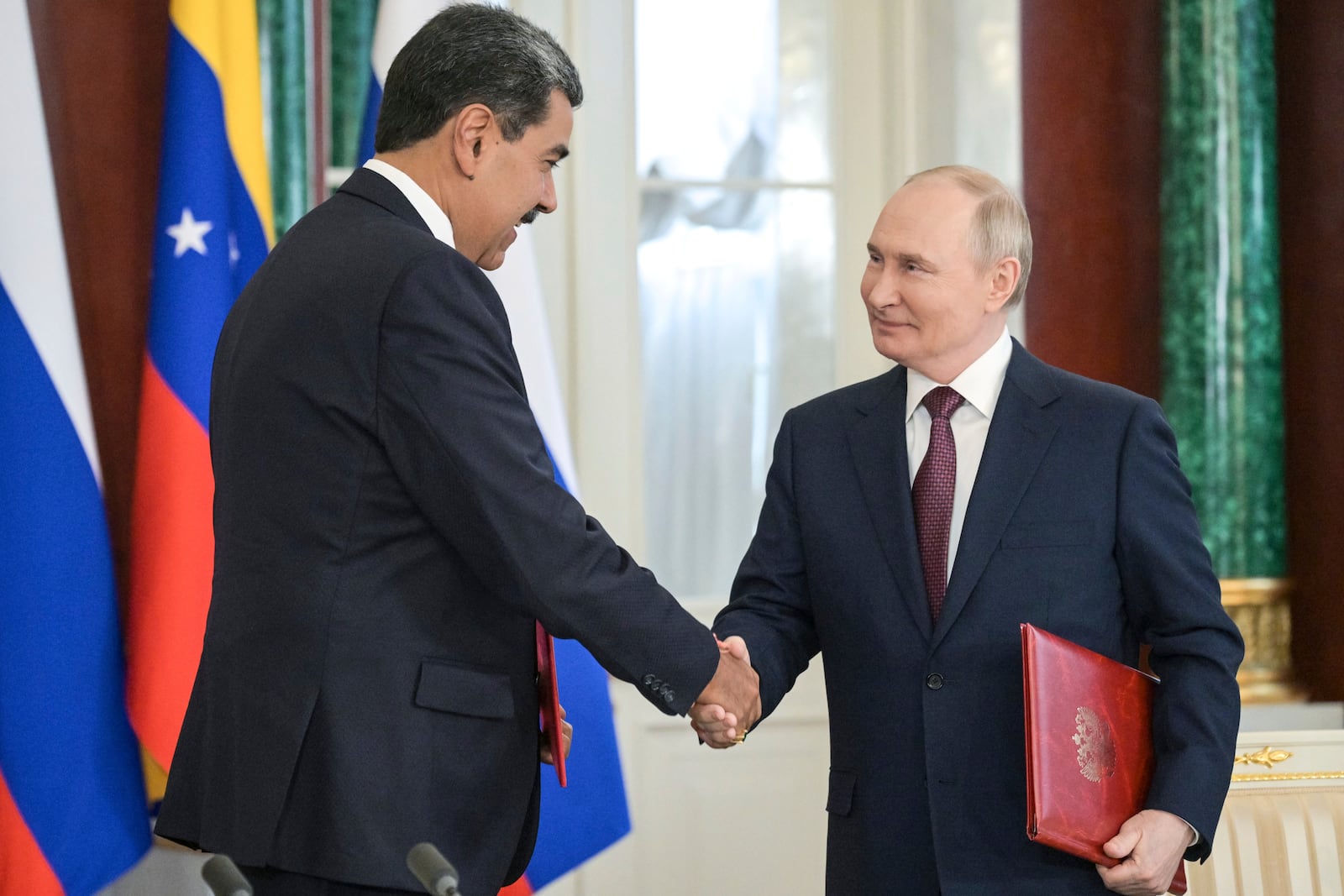 Venezuelan President Nicolas Maduro, left, and Russian President Vladimir Putin shake hands during a signing ceremony after their meeting at the Kremlin in Moscow, Russia, Wednesday, May 7, 2025, ahead of celebrations of the 80th anniversary of the Soviet Union's victory over Nazi Germany during the World War II. (Alexei Nikolsky/Photo host agency RIA Novosti via AP)