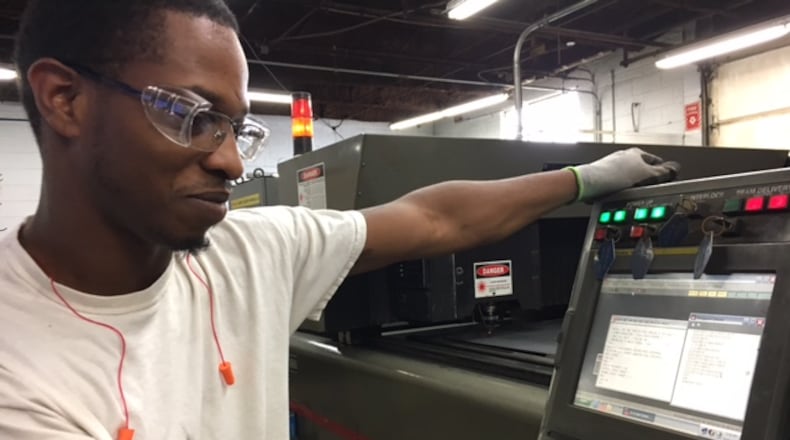 Dashaun Defurr, at work at Rack Processing in Moraine earlier this year. THOMAS GNAU/STAFF
