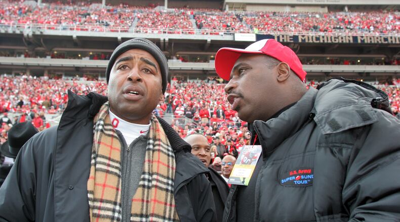 Former OSU football stars and Dayton natives Cris Carter (L) and Keith Byars chat on the sideline before the game.