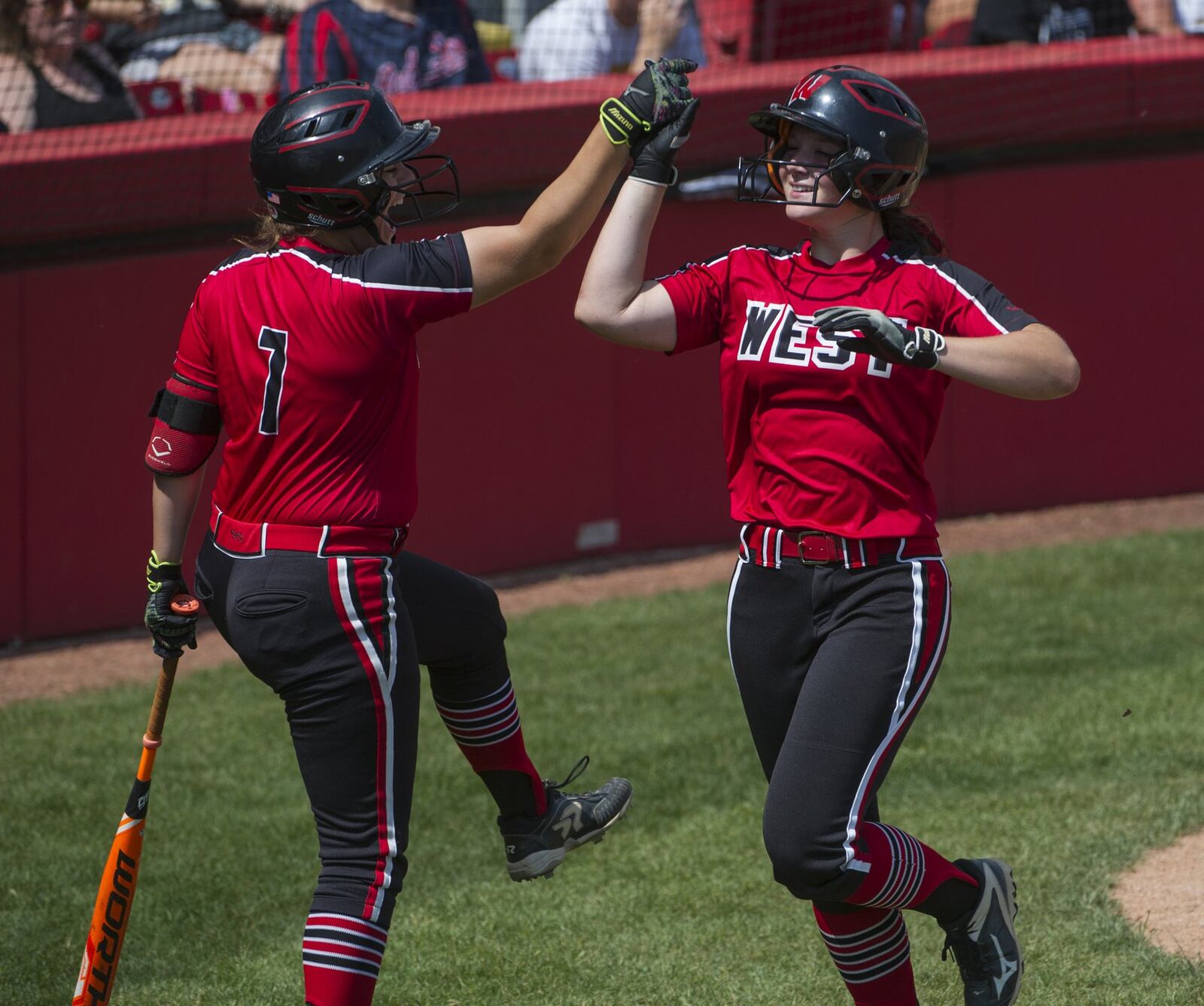 Lakota West’s Taylor Williams (right) celebrates with Remmie Steckler (7) after scoring against Perrysburg in Thursday afternoon’s Division I state semifinal at Firestone Stadium in Akron. West beat PHS 2-1 in eight innings. PHIL LONG/OHIO PRESS PHOTO SYSTEM