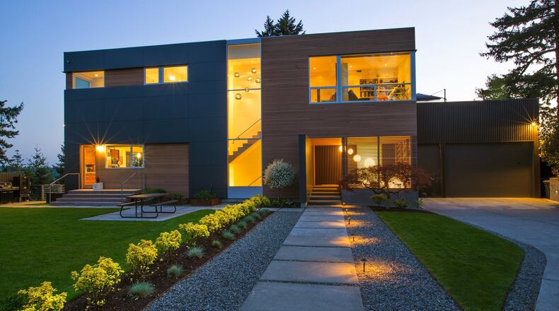 Because the residence sits directly on top of one of Bellevue s tallest hills, the approach needed to be dramatic, says architect Andrew van Leeuwen of BUILD. A ground-to-sky window is lit with six Graypants recycled cardboard lights that lead visitors to the house, where nine glowing spheres illuminate a covered, screened entry area. CLS Landscape Services did the landscaping. (Mike Siegel/The Seattle Times/TNS)
