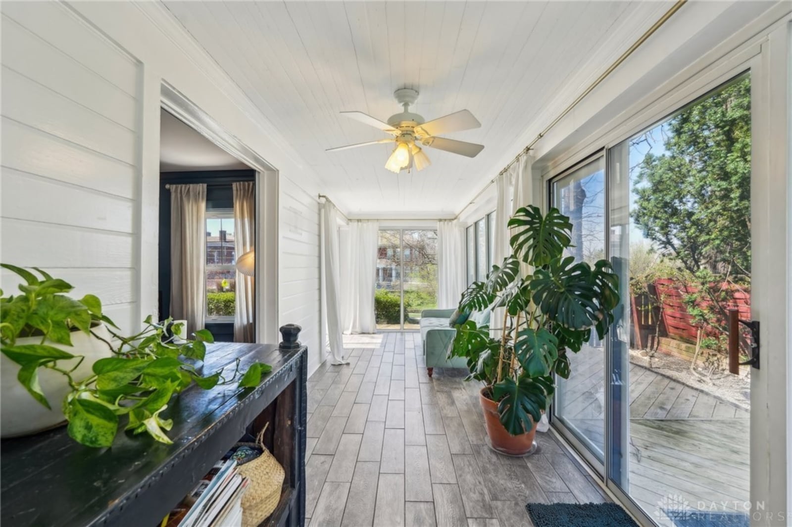 the sunroom has tile flooring and sliding glass doors accessing the exterior wood deck.