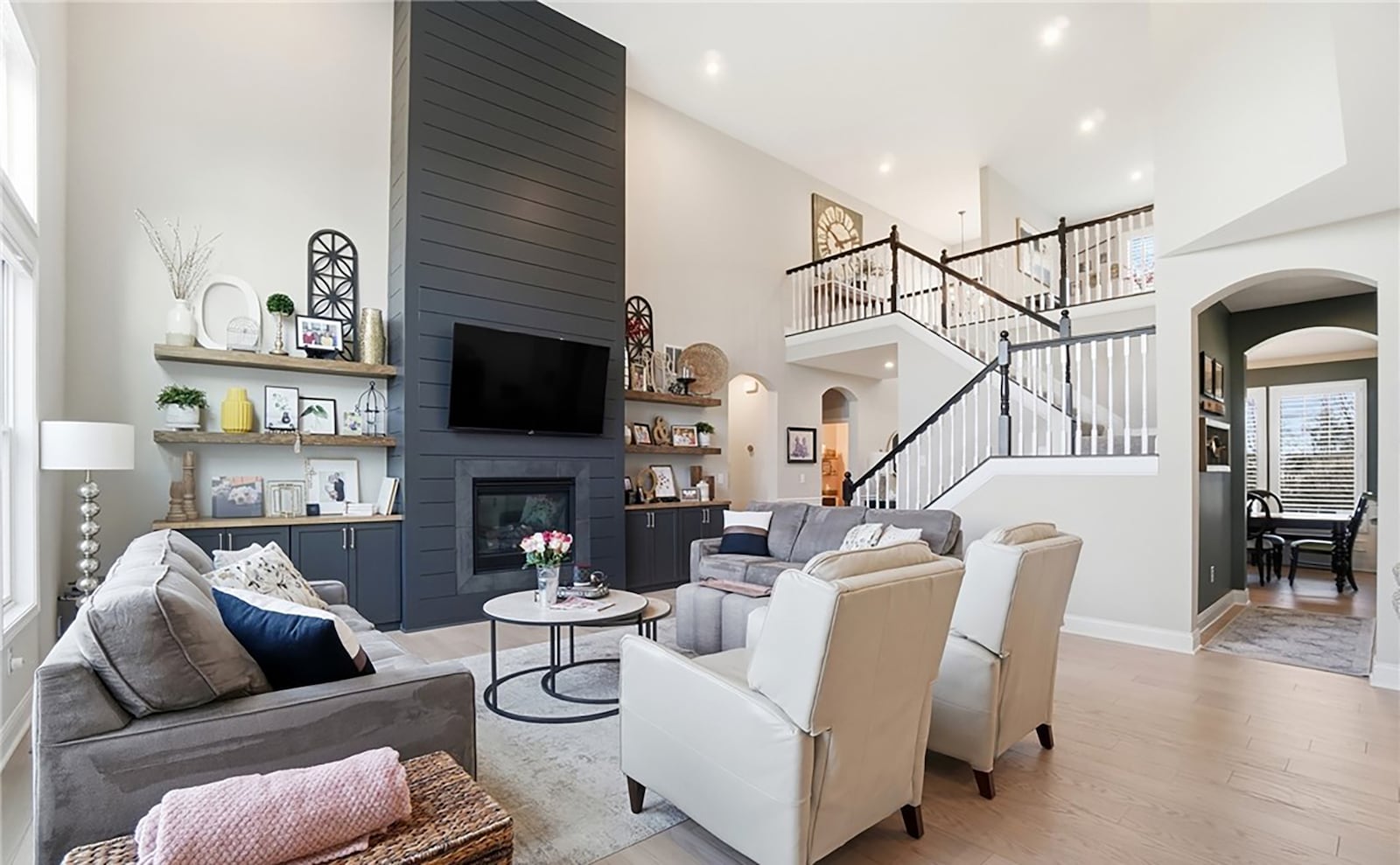 The two story great room has hardwood floors, a floor to ceiling gas fireplace with built ins on either side and recessed lighting. CONTRIBUTED