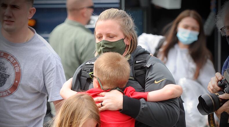 Major Erica Eyer, Receives hugs from two of her children Reagan, 8 and Brent, 5, After a two-month deployment administering COVID-19 vaccines in Michigan, Wright-Patterson Air Force Base Medical staff returned home Tuesday afternoon.