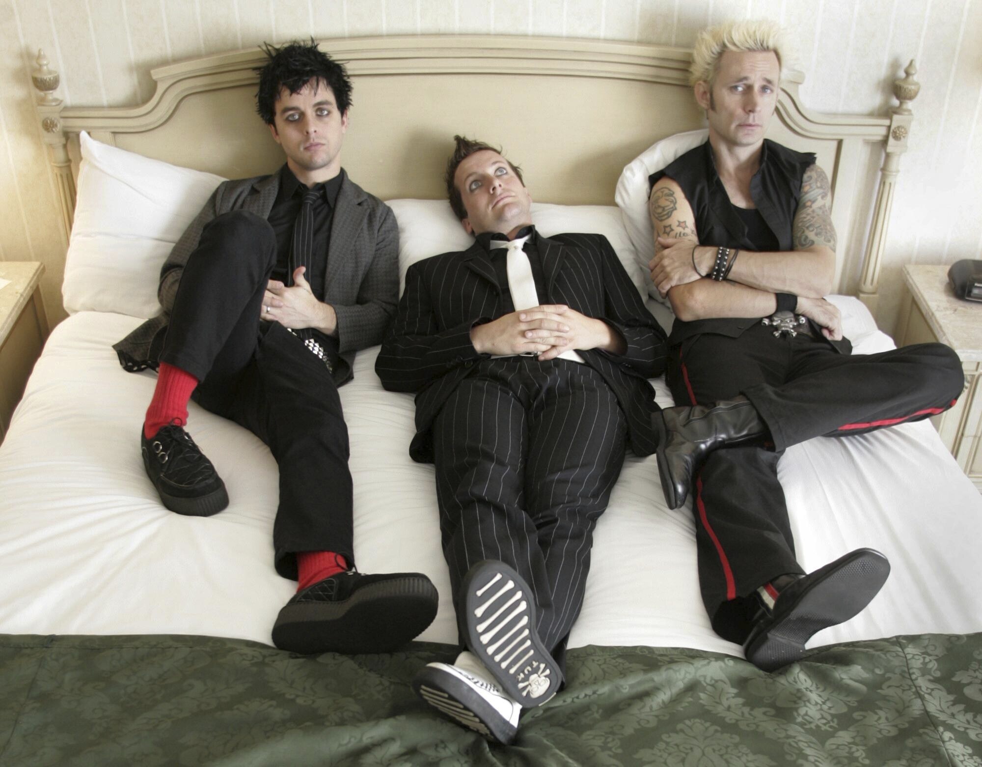 FILE - Members of Green Day, from left, Billie Joe Armstrong,, Tre Cool and Mike Dirnt pose in their hotel room in Toronto on Sept. 23, 2004. (Adrian Wyld/The Canadian Press via AP, File)