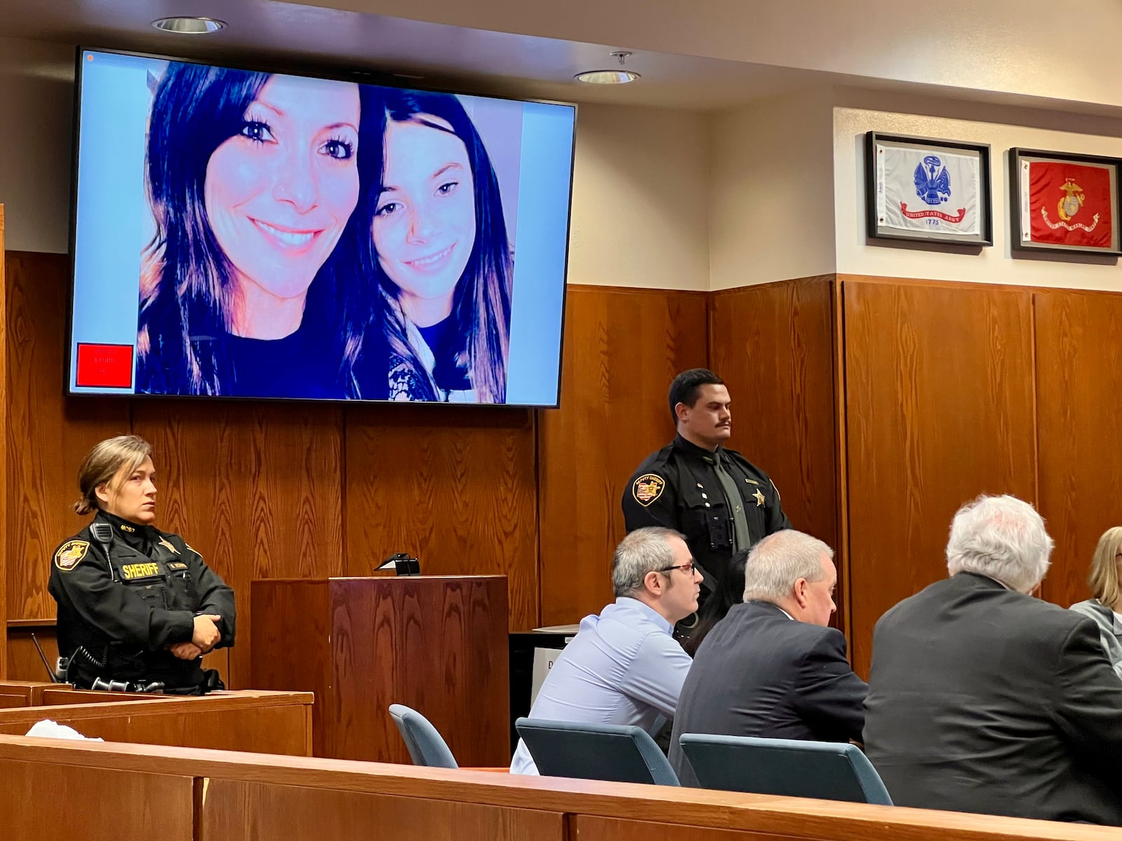 Stephen Marlow sits at left with his attorneys on Dec. 30, 2024, as a photo of homicide victims Sarah and Kayla Anderson is shown on a TV screen in Montgomery County Common Pleas Court. AIMEE HANCOCK/STAFF