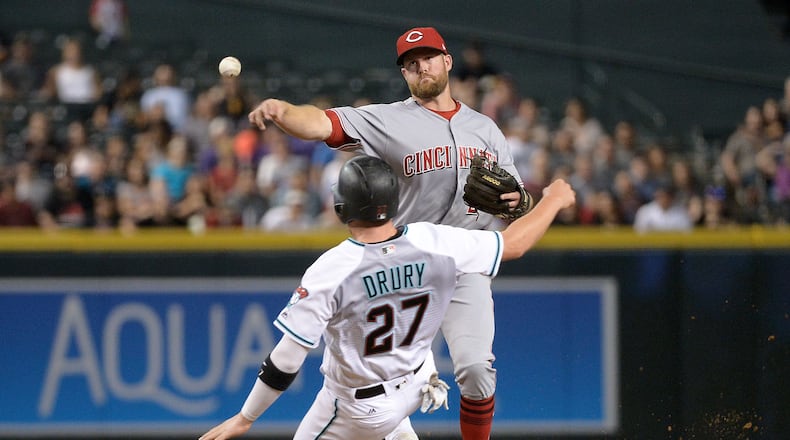 Reds shortstop Zack Cozart turns a double play over the sliding Brandon Drury of the Diamondbacks during the sixth inning at Chase Field on Friday in Phoenix, Arizona.