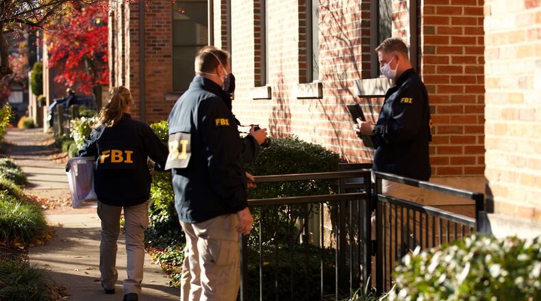 FILE-This Nov. 16, 2020 file photo shows FBI agents removing items from the home of then Public Utilities Commission of Ohio Chairman Sam Randazzo in Columbus, Ohio. State and federal officials are investigating whether Randazzo, the utility lawyer-turned-regulator who has since resigned, helped usher through a string of legislative and regulatory victories worth well over $1 billion over time to energy giant FirstEnergy Corp. and its subsidiaries, in exchange for cash. (Adam Cairns/The Columbus Dispatch via AP)
