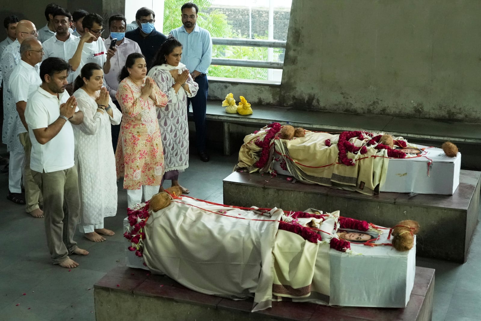 Family members of Dilip Patel and Meena Patel, both victims of the Air India plane crash, pays last respect to their parent during the cremation at a crematorium in Ahmedabad, India, Monday, June 16, 2025. (AP Photo/Ajit Solanki)
